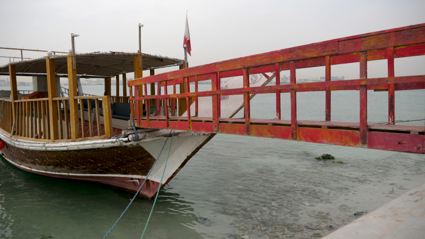 Old wooden dhow boat is slowly rocking in harbor of Doha Fishing boats Dhow in Doha Harbor  in Doha, Qatar, Middle East