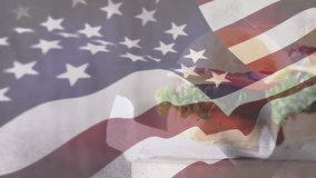 Digital composite of a two servings of burgers with an american flag waving in the foreground - Powered by Shutterstock - Get 15% off with code: PIKWIZARD15