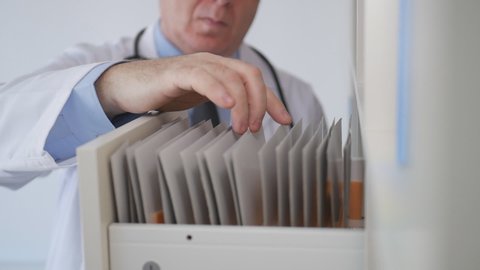 Slow Motion with Doctor Opening a Drawer and Looking for Medical Documents