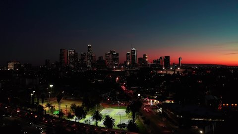 Los Angles, CA / USA - April, 20, 2019: Aerial riser view of downtown Los Angeles in California USA after sunset during twilight with cars moving in traffic on freeway