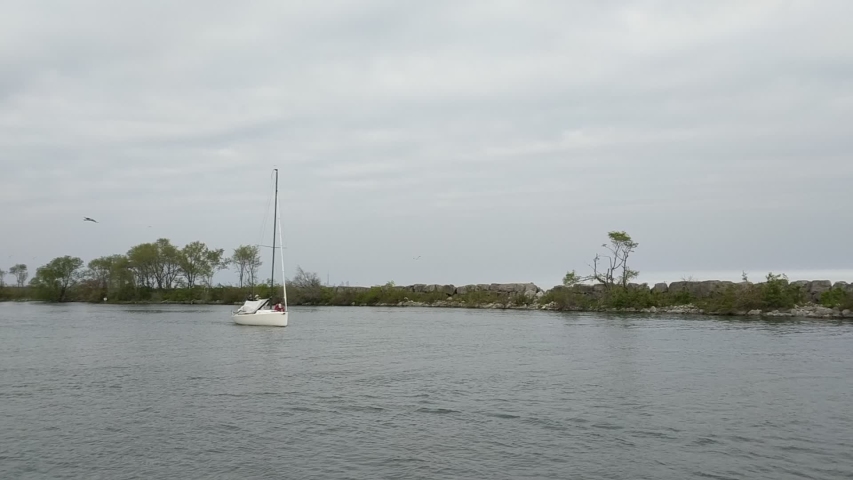 4K video footage of a yacht sailboat slowly sailing in the marina. Lake Ontario, Canada.