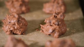 Chocolate cookie dough in a metal tray. Selective focus. Panning to the left.
