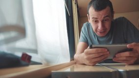 man playing an online game on a smartphone, strong emotions, anger man sitting in a train by the window. slow motion video. train emotions joy surprise lifestyle journey concept - Powered by Shutterstock - Get 15% off with code: PIKWIZARD15