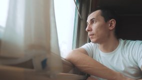 man rides train railway looks out the window. traveler concept train railroad journey travel lifestyle. slow motion video. beautiful from window of a moving train railway trip Russia winter