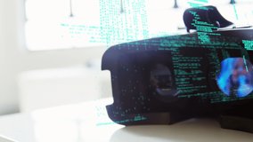 Digital composite of a virtual reality headset on a table with interface codes on the foreground - Powered by Shutterstock - Get 15% off with code: PIKWIZARD15