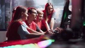 Young gamers team plays a video game, players discuss strategy and game plan, colored neon lighting, cybersportsmans.