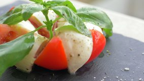 Beautifully arranged salad Caprese on a black background. Enjoy your meal