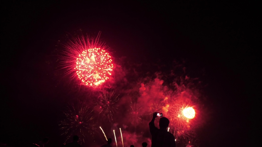 Crowd of silhouetted people watching fireworks show | Shutterstock HD Video #1030885922