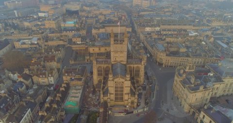 Warm sunrise aerial circling the Anglican Church Bath Abbey in the historic Roman city of Bath Spa in England