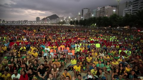Copacabana, Rio de Janeiro/Brazil - 30th December 2014: Crowd of Brazilians celebrating Brazilian goal on beach cheering and jumping from their seats, letting off fireworks