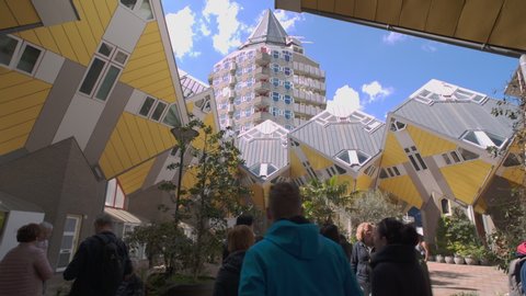 ROTTERDAM, HOLLAND - April 2019: Kubuswoningen, tourists walking through Cube house patio in Rotterdam, South Holland, the Netherlands. Innovative cube-shaped houses designed by architect Piet Blom.