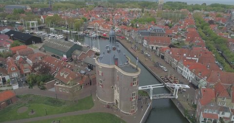 Aerial circling the Drommedaris Defence tower in historic Dutch town Enkhuizen in North Holland the Netherlands revealing the white wooden drawbridge