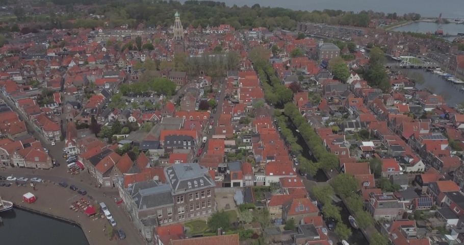 Aerial of traditional buildings and rooftops in historic Dutch town Enkhuizen in North Holland the Netherlands with sea in the background Royalty-Free Stock Footage #1030886462
