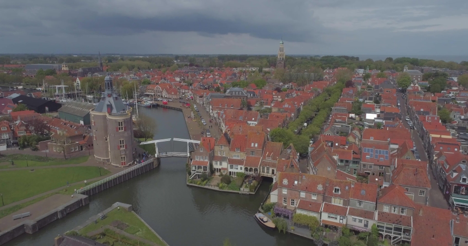 Aerial of historic Dutch town Enkhuizen in North Holland the Netherlands rising up past Drommedaris Defence tower and town gate Royalty-Free Stock Footage #1030886471