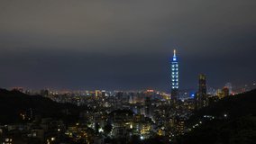 Beautiful aerial view of Taipei city skyline at night with the city lights slowly turns off with Taipei 101 and national landmarks surrounded by mountains, Video noise due to low light.