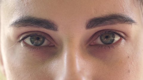Close-up of beautiful green female eyes. The girl opens her eyes