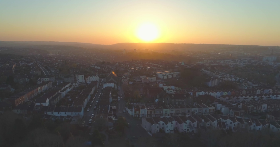 Aerial towards warm golden sun setting over suburban English houses Royalty-Free Stock Footage #1030893722