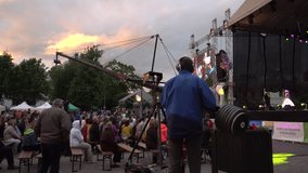 Dobele, Latvia - May 25 of 2019. Festive in the city square. Work of TV and video operator using a special technique. Cameraman at the filming crane working in the twilight. 