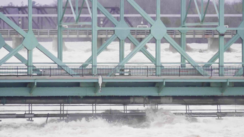 Telephoto shot of high water from the Ottawa River hitting the Chaudiere Bridge. Slow motion, alternative version