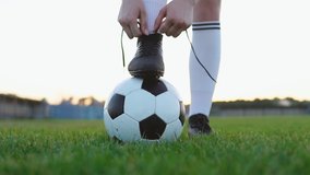 Close up of a female soccer player tying shoelace on football field, slow motion - Powered by Shutterstock - Get 15% off with code: PIKWIZARD15