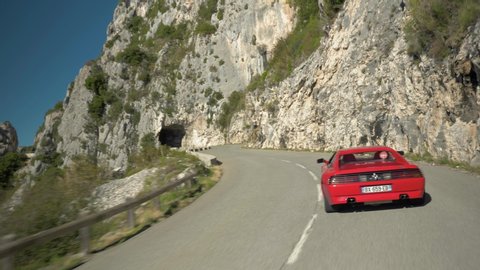 Saint Paul De Vence, France - 10 13 2018: Driving behind a red Ferrari 348 into a mountain road tunnel in France during the Boucle Historique vintage sports car rally.