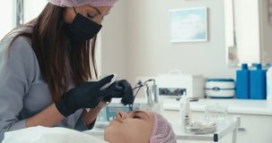Microblading eyebrows work flow in a beauty salon. Woman having her eye brows tinted. Semi-permanent makeup for eyebrows. 4K slow motion raw video footage 60 fps
