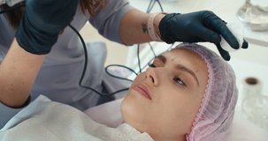 Microblading eyebrows work flow in a beauty salon. Woman having her eye brows tinted. Semi-permanent makeup for eyebrows. 4K slow motion raw video footage 60 fps
