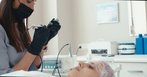 Microblading eyebrows work flow in a beauty salon. Master preparing machine for tattoo. Semi-permanent makeup for eyebrows. 4K slow motion raw video footage 60 fps