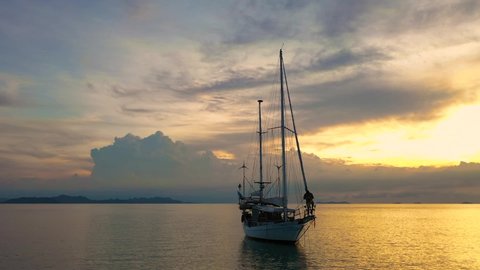 Samui / Thailand - 05 28 2019: A sailing ship with two masts sails off the coast of Samui Island. Shot from drone