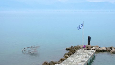 NAFPLIO, ARGOLIS / Greece - 12 04 2018: NAFPLIO, GREECE, 02 DEC 2018 : Man fishing on dock in Nafplio city, Greece