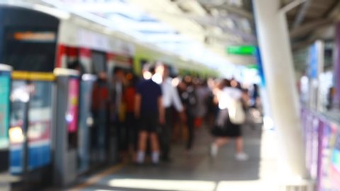 Blurry of people walking to getting on and getting out electric skytrain with automatic gateway, railroad transportation for passenger in city, traveler and urban lifestyle. BTS.