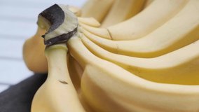 Ripe banana fruit on wooden table. Selective focus. Tilt up footage.