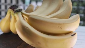 Ripe banana fruit on wooden table. Selective focus. Panning to the right.