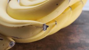 Ripe banana fruit on wooden table. Selective focus. Panning to the right.