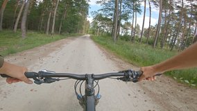 Riding enduro mountain bike on rocky path road between green fields. View from first person perspective POV. 4K gimbal stabilized video, Gopro Hero 7 black.