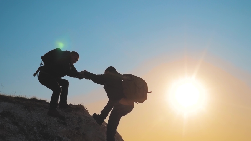 teamwork help business travel silhouette concept. group of tourists lends a helping hand climb the cliffs mountains. people climbers climb to the top overcoming hardships the path lifestyle to victory Royalty-Free Stock Footage #1030954844