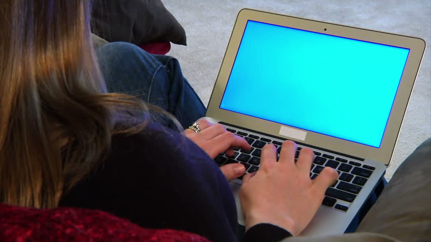 A woman types on her laptop computer.  Bluescreen with luma matte for your on