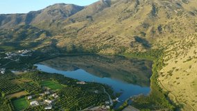 Aerial drone panoramic video of famous natural lake of Kournas with amazing colours and unique nature surrounded by mountains, Chania prefecture, Crete island, Greece