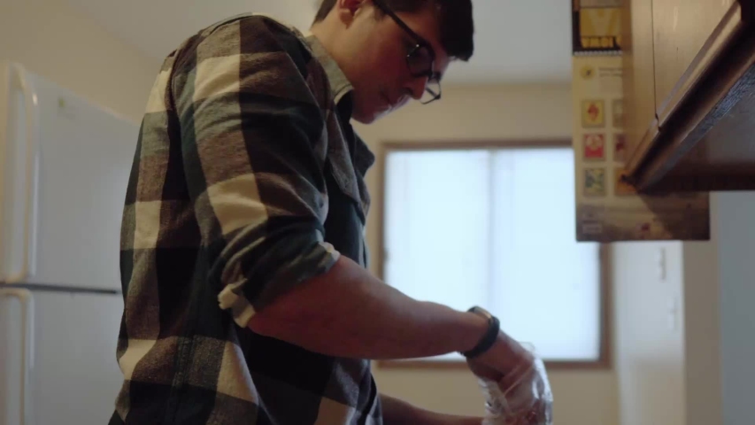 Person weighing out food in the kitchen. Slow pan down. Shallow depth of field. 24 fps.