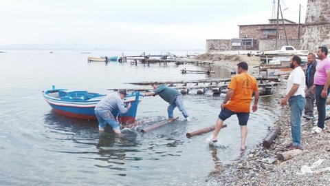 Mytilene, Greece - 12 13 2018: Fishermen messing launching boat