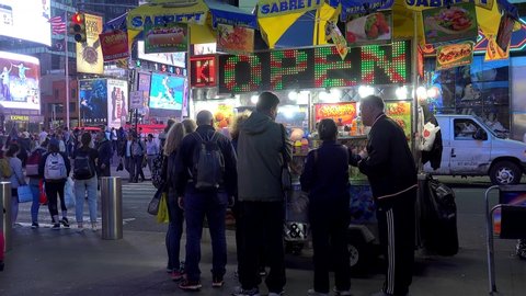 NYC, NEW YORK / USA - APRIL 23, 2019:
Customers at the Halal Food Cart on Times Square by night. 