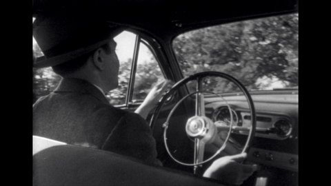 1950s: Man drives car down road. Woman drives convertible down the road.