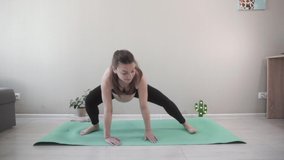 A pregnant girl in the room, on a green rug does yoga. The action takes place at home. Videos can be used in pregnant films.
