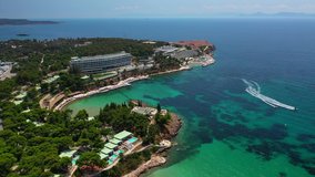 Aerial drone video of famous celebrity sandy beach of Astir or Asteras in south Athens riviera with emerald clear sea, Vouliagmeni, Attica, Greece