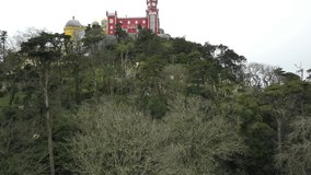 The Pena Palace, a Romanticist castle in the municipality of Sintra, Portugal, Lisbon district, Grande Lisboa, aerial view, shot from drone. Camera moves upwards