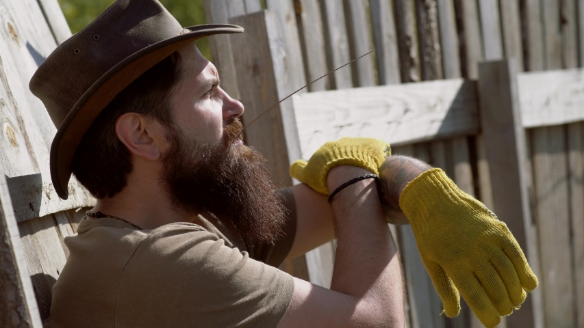 Portrait of handsome young bearded man on spring background. Man farmer concept. Retro farmer man. Eco farm. Full body portrait of bearded man farmer with shovel having fun in a farm