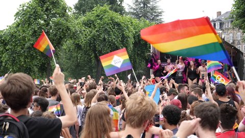Strasbourg, France - Jun 8, 2019: Slow motion large happy crowd of men women people lesbian and gay with gay rainbow flags Bisexual Transgender LGBT GLBT dancing techno music