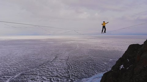 Balance on the horizon. Slackliner is on a tight rope and falls.