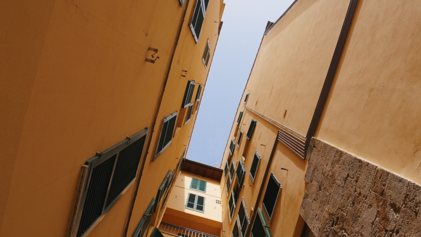 View of the buildings narrow street. The camera goes down and a woman appears