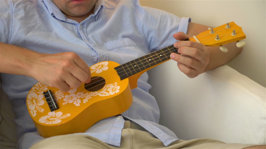 Man playing ukulele in slow motion 180fps
